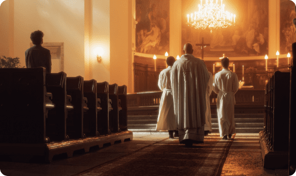 A procession of a Priest, the cross bearer and acolyte with candle at the start of a Catholic Mass.